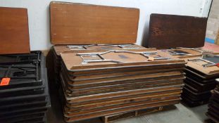 Lot of (25) assorted 6 ft by 30 in wood tables with folding legs on a pallet