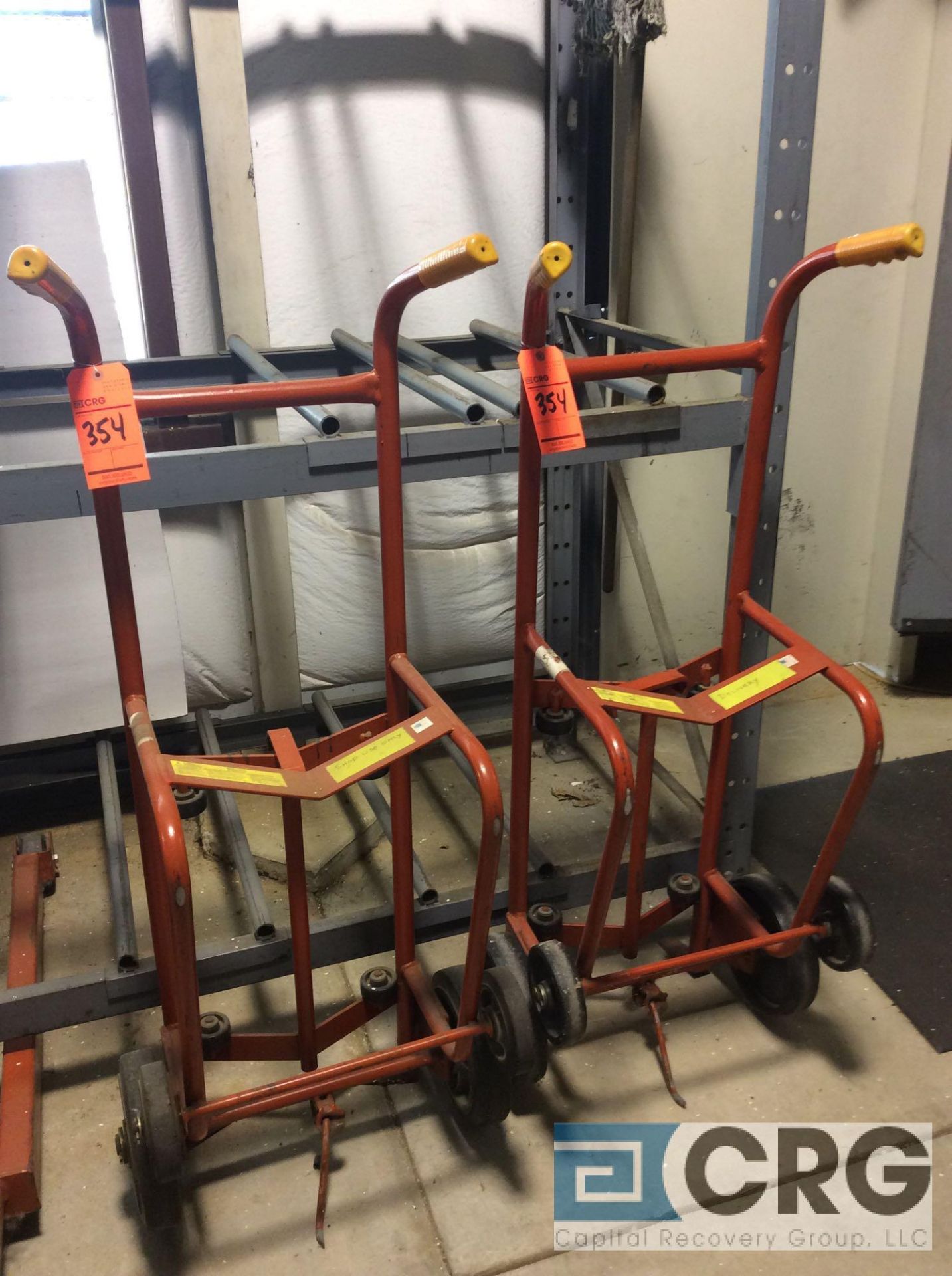 Lot of (2) Wesco 1000 lb capacity 55 gallon drum hand trucks with (3) asst drums oils and lubes with