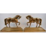 A pair of brass hearth ornaments, in the form of horses, 22.