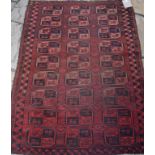 An Afghan rug, decorated lozenges on a red ground, within a multi border,
