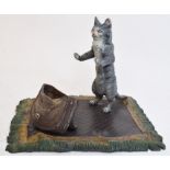 A novelty painted bronze pen stand, in the form of a cat on a rug,