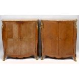 A pair of French serpentine front cabinets, veneered in kingwood, each with a marble top,