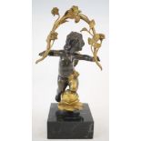 A bronze putto, with gilt decoration on a marble base,