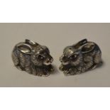 A pair of novelty silver salt and pepper pots, in the form of rabbits, with ruby eyes, 2.