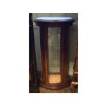 A French oval display cabinet, with a marble inset top, on brass paw feet,