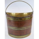 A 19th century mahogany bucket, of navette form, bound in brass, and with a brass handle and liner,