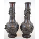 A pair of Japanese bronze vases, each decorated a dragon, birds, flowers and foliage,