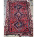 A Shiraz rug, decorated central medallions on a red ground within a multi border,