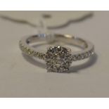 A 9ct white gold and diamond cluster ring, with diamond set shoulders,