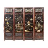 A Chinese hardwood four fold screen, each black lacquered section applied hardstones,