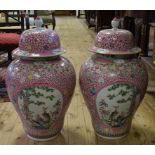 A pair of large Chinese famille rose vases and covers, decorated birds, flowers, and foliage,