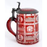 A Bohemian flashed and etched ruby glass tankard, decorated buildings,