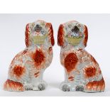 A pair of Victorian Staffordshire pottery figures, of spaniels holding baskets, 18.