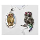 A silver owl brooch, with ruby eyes, and