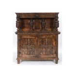 An inlaid oak court cupboard, carved shells, figures, face masks and foliage,