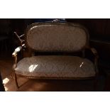 A French two seater upholstered settee, on turned and fluted legs,