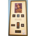 A frame of items, paying homage to Baden Powell, including medallions and badges,