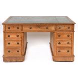 A late Victorian oak pedestal desk, the leather inset top above an arrangement of nine drawers,