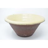 A pottery mixing bowl, with a light green glaze,