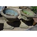 A pair of reconstituted stone pedestal garden urns,