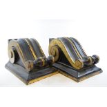 A pair of black painted composition corbels, with gilt decoration,