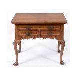 An early 18th century walnut lowboy with feather banding,