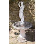 A reconstituted stone fountain, surmounted by a classical lady,