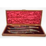 A bone handled carving set, cased, an ebony desk set,