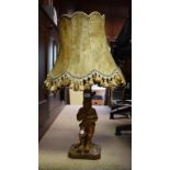 A carved wood lamp in the form of a young man holding his hat with two ducks in it,