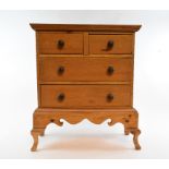 A table top miniature pine chest of drawers, an Edwardian mantel clock, in an inlaid mahogany case,