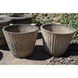 A pair of reconstituted stone garden urns, of tapering cylindrical form ,