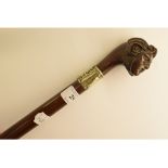 A carved wood handled walking cane, of a