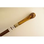 A walking cane, having a turned wood par