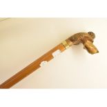 A carved wood handle walking cane, model