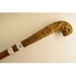 A carved wood handled walking cane, deco