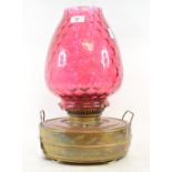 A large conservatory lamp, with cranberry glass shade, 43.5 cm high, and eleven other oil lamps (12)