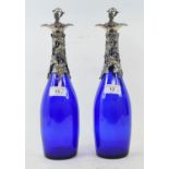 A pair of blue glass decanters, with metal grape and vine leaf mounts and stoppers, 34 cm high (2)