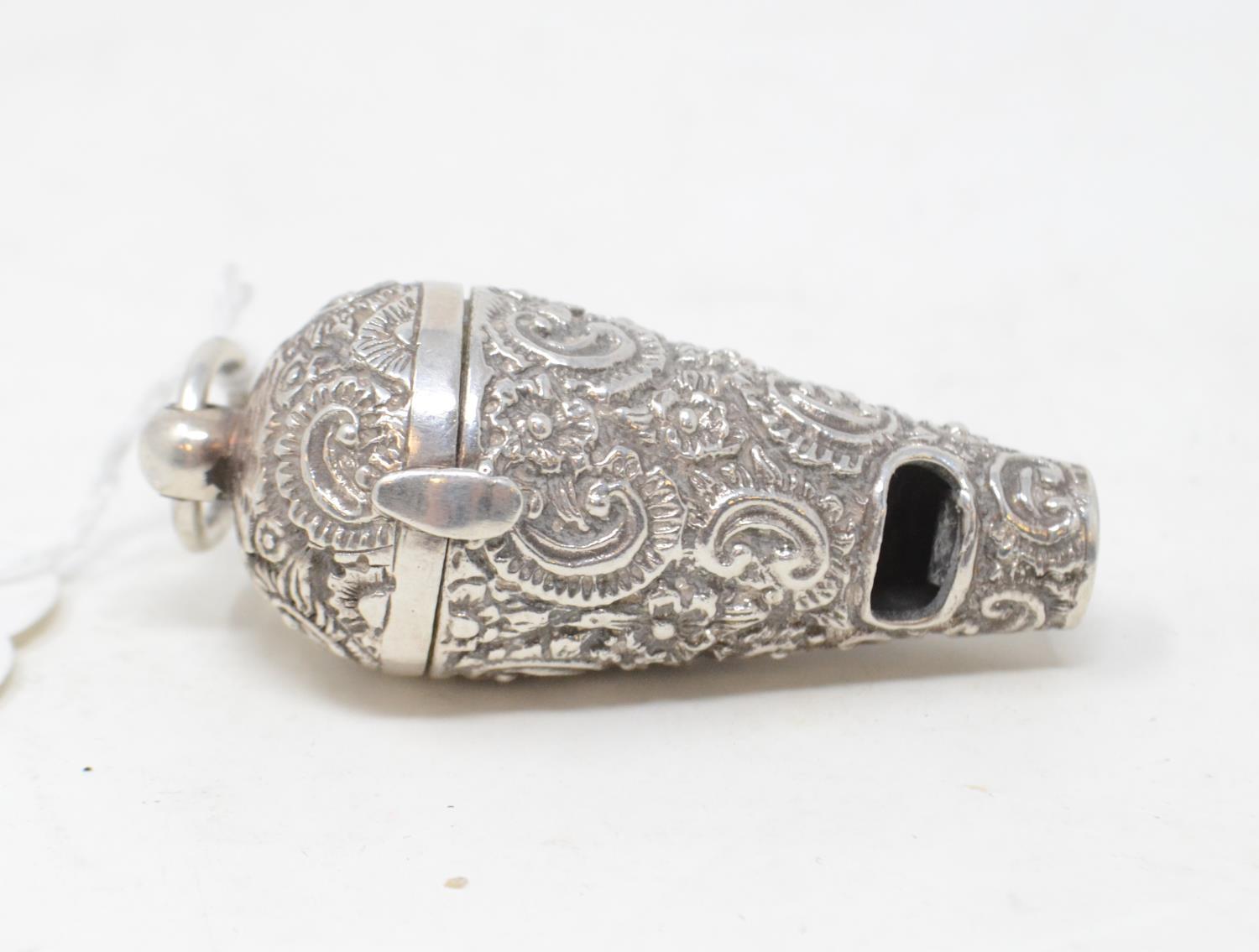 A silver novelty whistle/vinaigrette, with embossed decoration