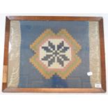 A Native Indian flat weave rug, with geometric medallion, 42 x 43 cm, framed