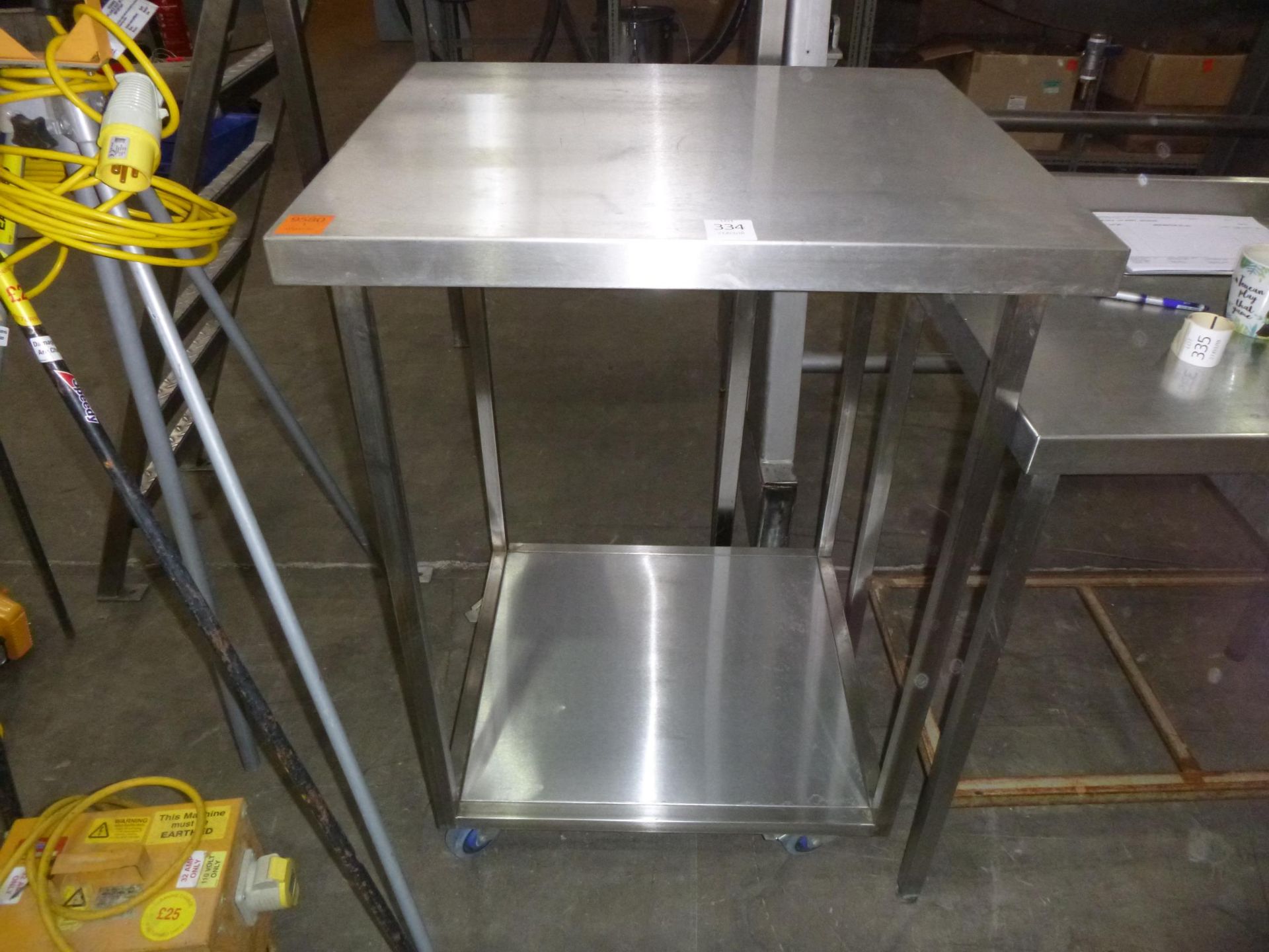 * A Stainless Steel Preparation Table with undertier on castor wheels