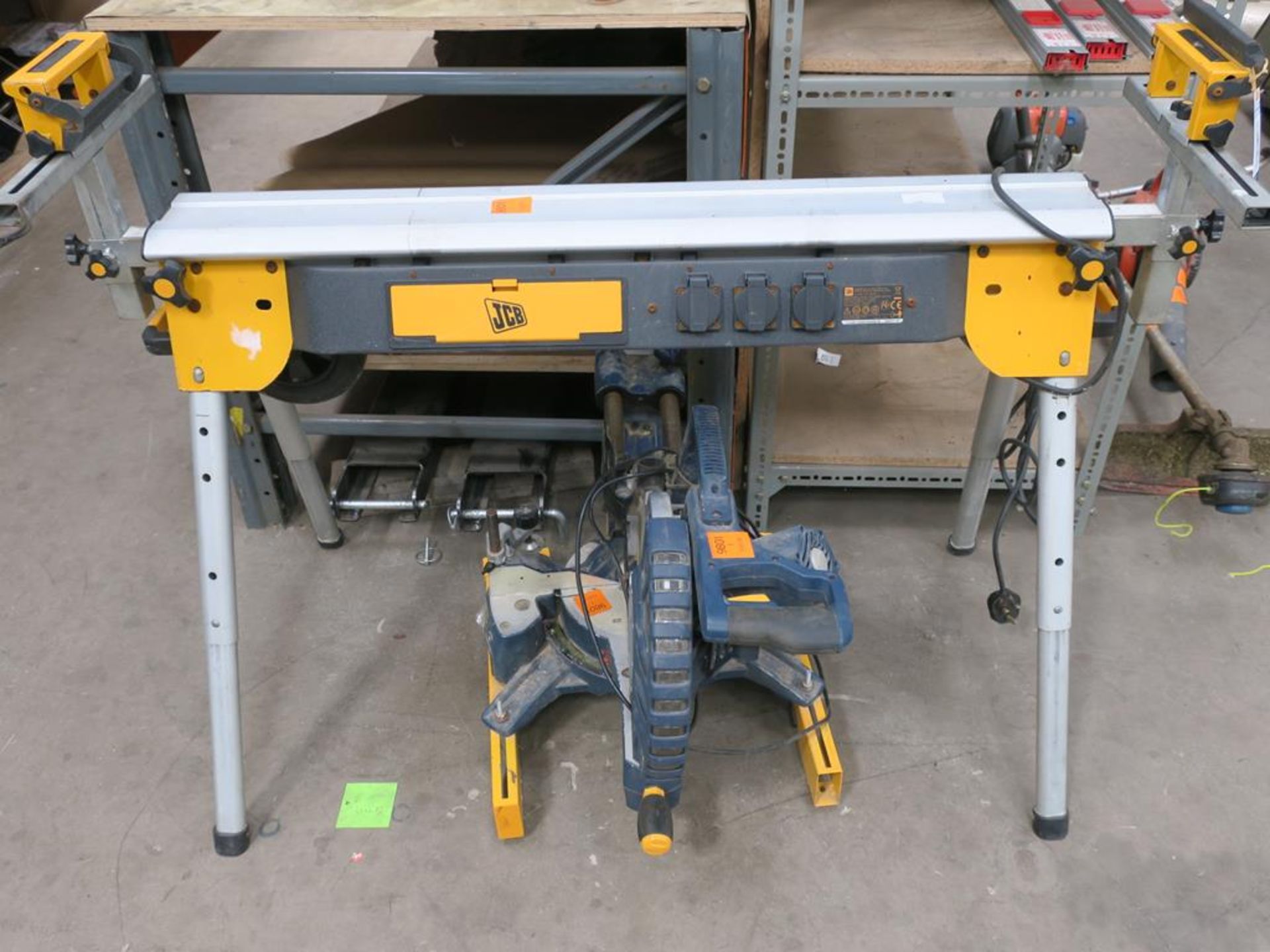 A JCB Mitre Saw, Work Bench (Wheeled) with Extending Legs and Fitted with three power points (Bed