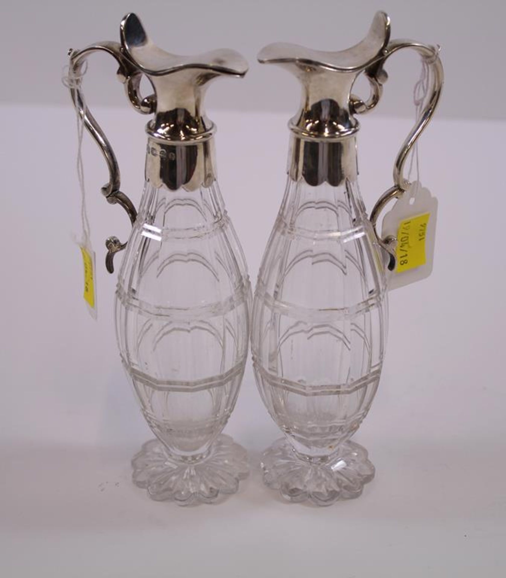 A pair of Victorian Scottish silver mounted ovoid cut glass Ewers with scroll handles and plain