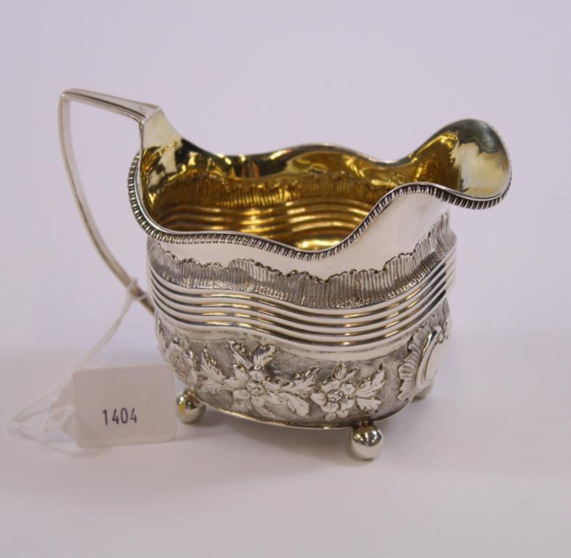 A George III silver Cream Jug of rectangular shape with angular handle, embossed body and ball