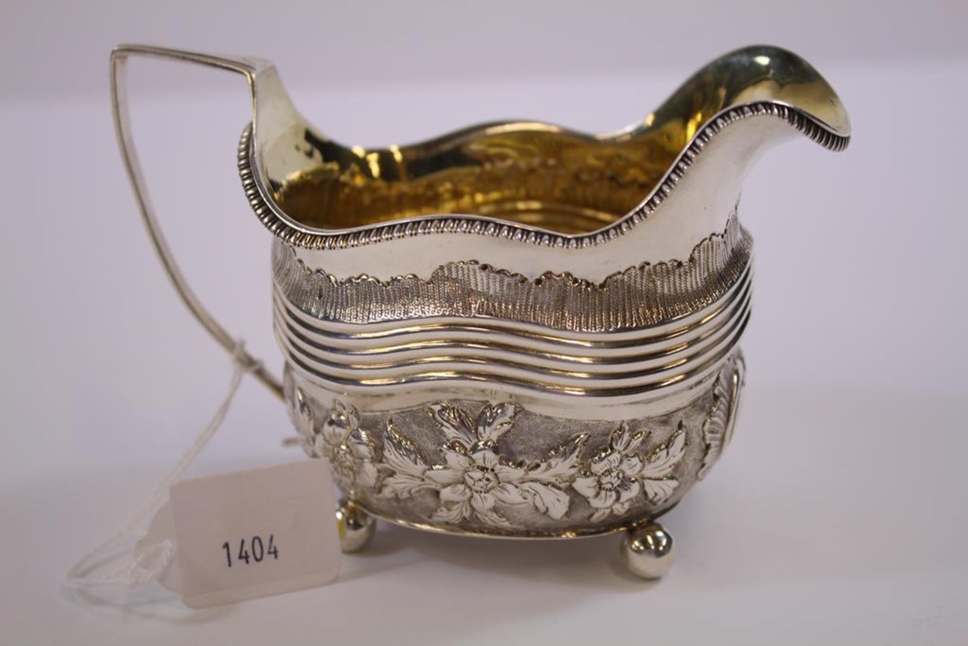 A George III silver Cream Jug of rectangular shape with angular handle, embossed body and ball - Image 2 of 3