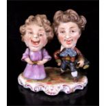 Derby porcelain group, two large headed caricature figures, red crown mark to underside. 8cm by 8.