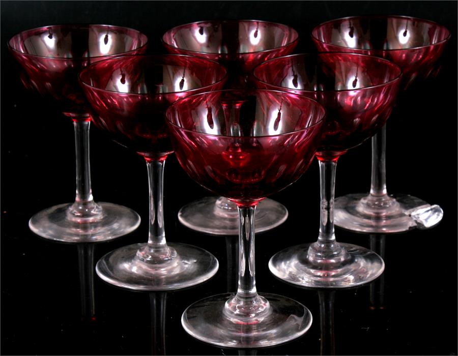 A set of six Bohemian flashed cranberry glass champagne saucers, one a/f, one with chip to foot rim.