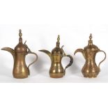 A group of three Turkish or Islamic brass dallah coffee pots, the largest 26cms (10.25ins) high (