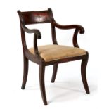 A Regency mahogany desk or carver chair with upholstered seat, on sabre front supports.