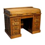 An early 20th century tambour topped twin pedestal desk, the tambour top above a single frieze