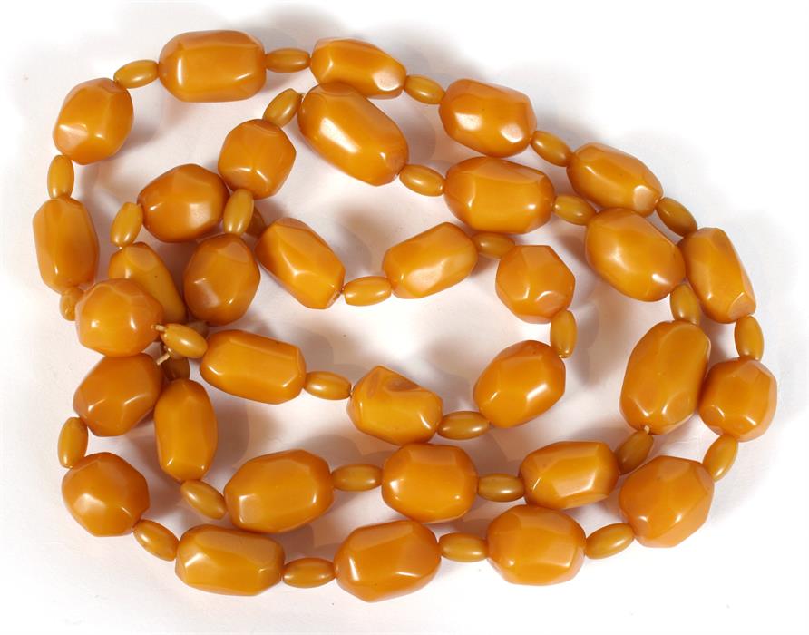 A string of Art Deco faceted butterscotch Bakelite amber beads, the largest bead 3cm (1.24ins) long.